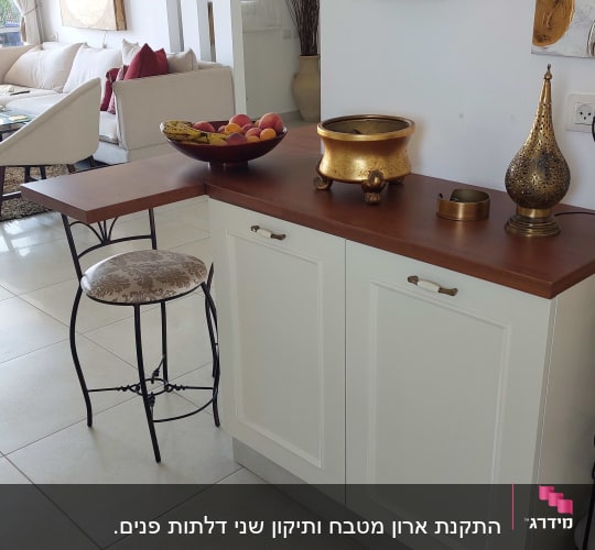 מדף עם צנצנות אדומות, קערת פירות על השיש